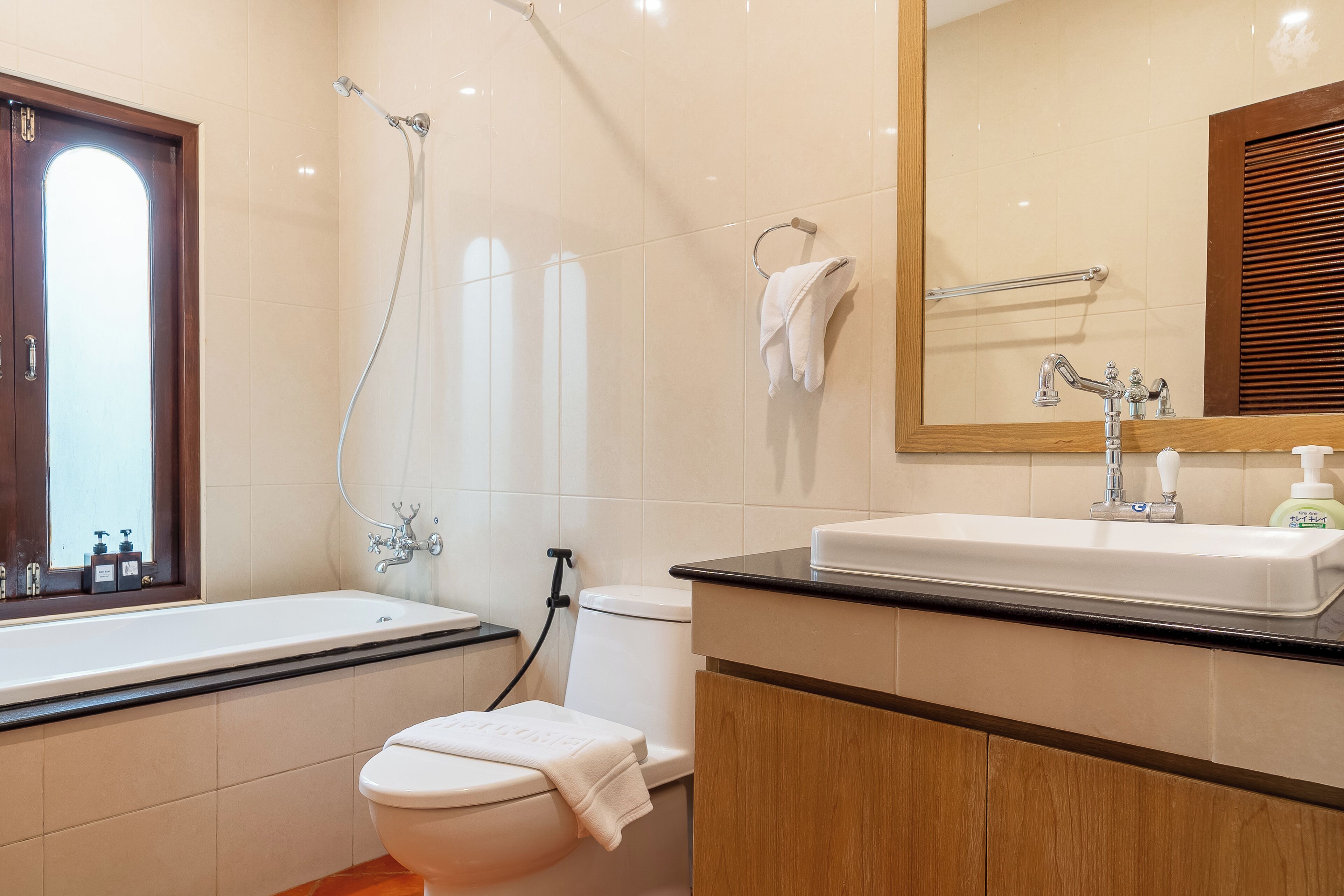 A modern bathroom with a bathtub, toilet, and sink.