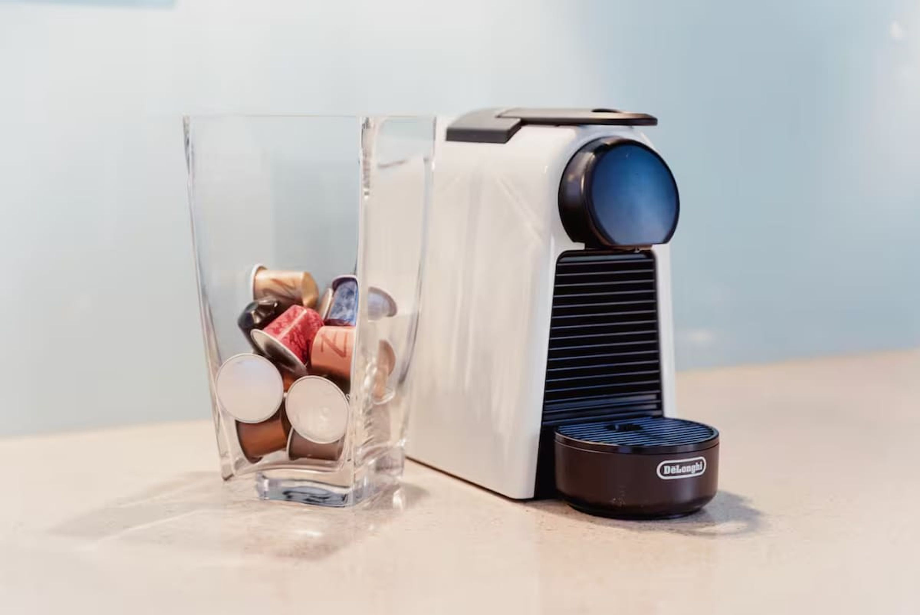 En kaffemaskine med en gennemsigtig beholder fyldt med kaffekapsler.
