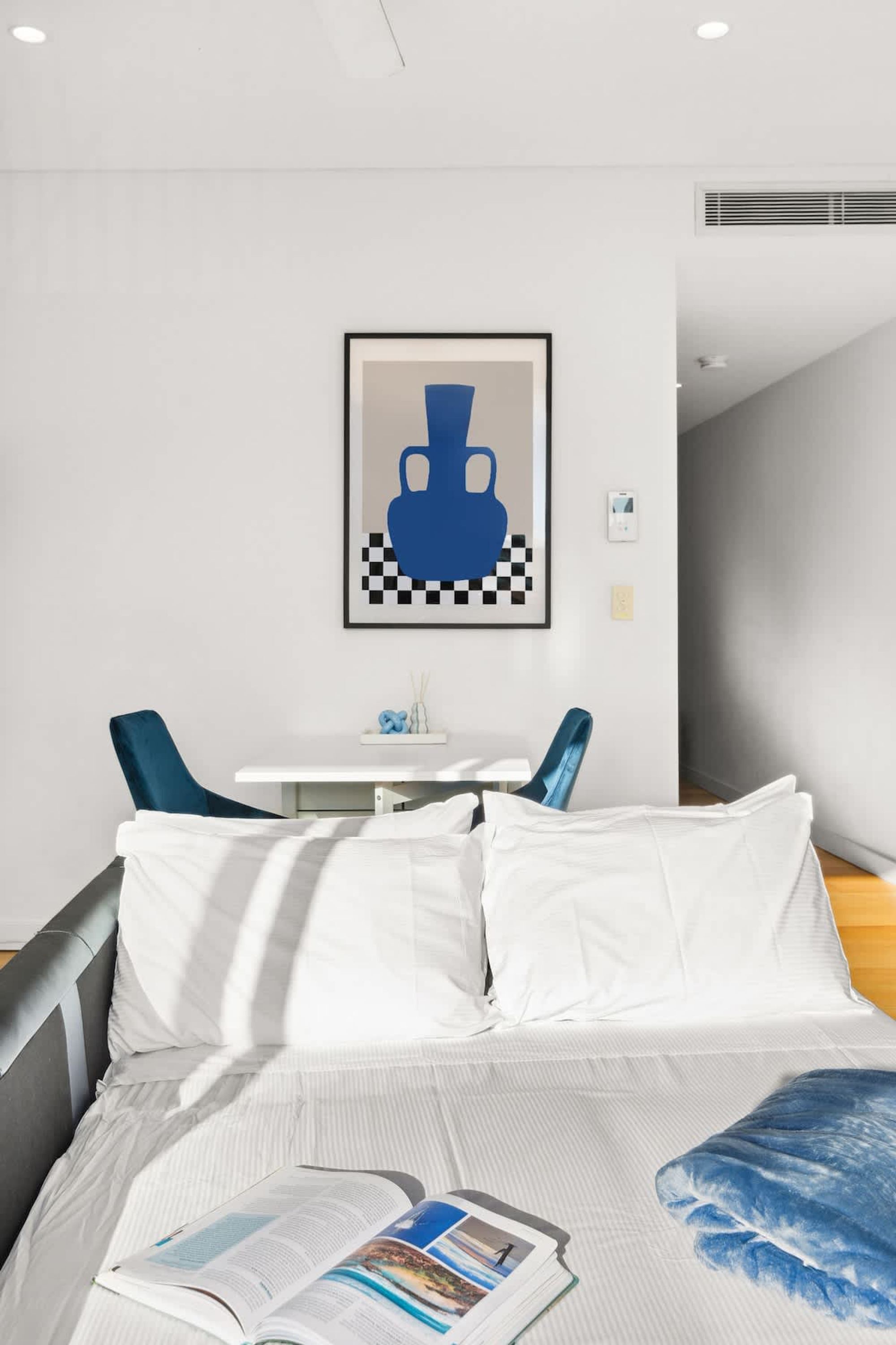 A modern hotel room with a bed, a small table, and two chairs.