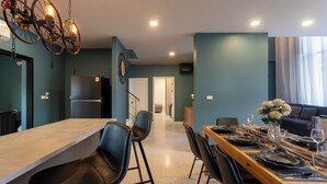 Une cuisine moderne dotée d’un îlot central, de chaises noires et d’une table à manger pouvant accueillir six personnes.