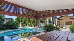 A covered outdoor area with a pool, wooden benches, and a pergola. - Seadrift 4 on Browning Street (Byron)