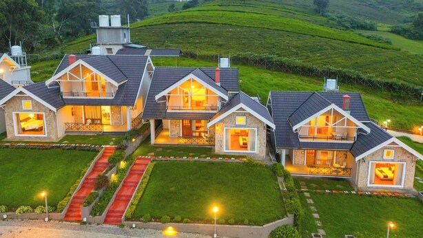 A series of modern houses with large windows and balconies, surrounded by lush green hills. - AJ Gable clouds Ooty by VOYE HOMES  (Ootacamund)