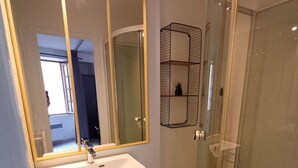 A modern bathroom with a glass-enclosed shower, a large mirror, and a wooden vanity. - Le Coin du Palan Chateauroux Hyper Centre (Chateauroux)