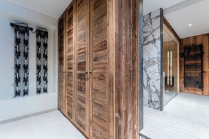A modern interior with a wooden panel wall, a glass door, and a marble accent wall.