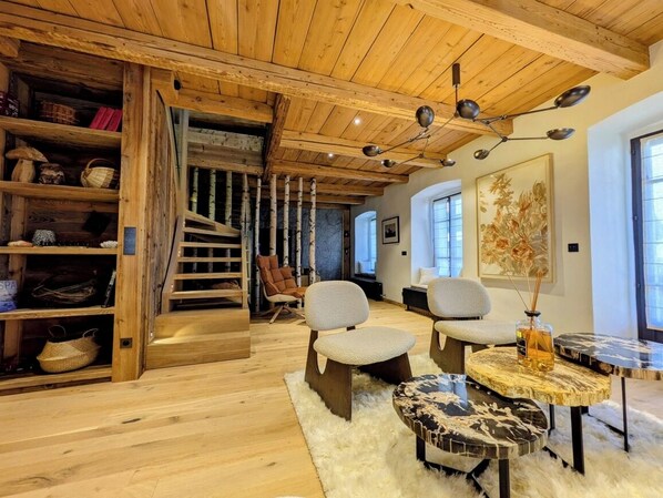 A wooden interior with a staircase, seating area, and a table. - Nuage apartment, Megeve village center. Luxury, Art & Wellness (Megève)