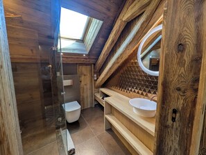 A wooden interior with a skylight, a toilet, a sink, and a mirror. - Nuage apartment, Megeve village center. Luxury, Art & Wellness (Megève)