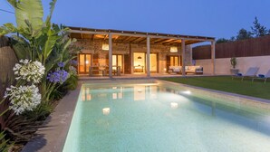 Una casa moderna con piscina, terraza cubierta y jardín bien cuidado.