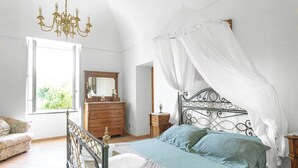 A bedroom with a four-poster bed, a wooden dresser, a mirror, and a window with curtains. - Villa Rosa: jacuzzi with Sorrento coast view (Massa Lubrense)