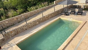 A rectangular pool with stone walls and a tiled deck. - Villa for 8 people in Višnjan near Poreč (Višnjan)