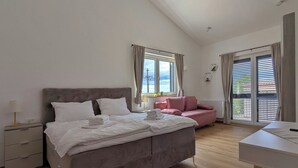 A bedroom with a bed, a bedside table, a desk, and a pink chair. - Villa for 8 people in Višnjan near Poreč (Višnjan)