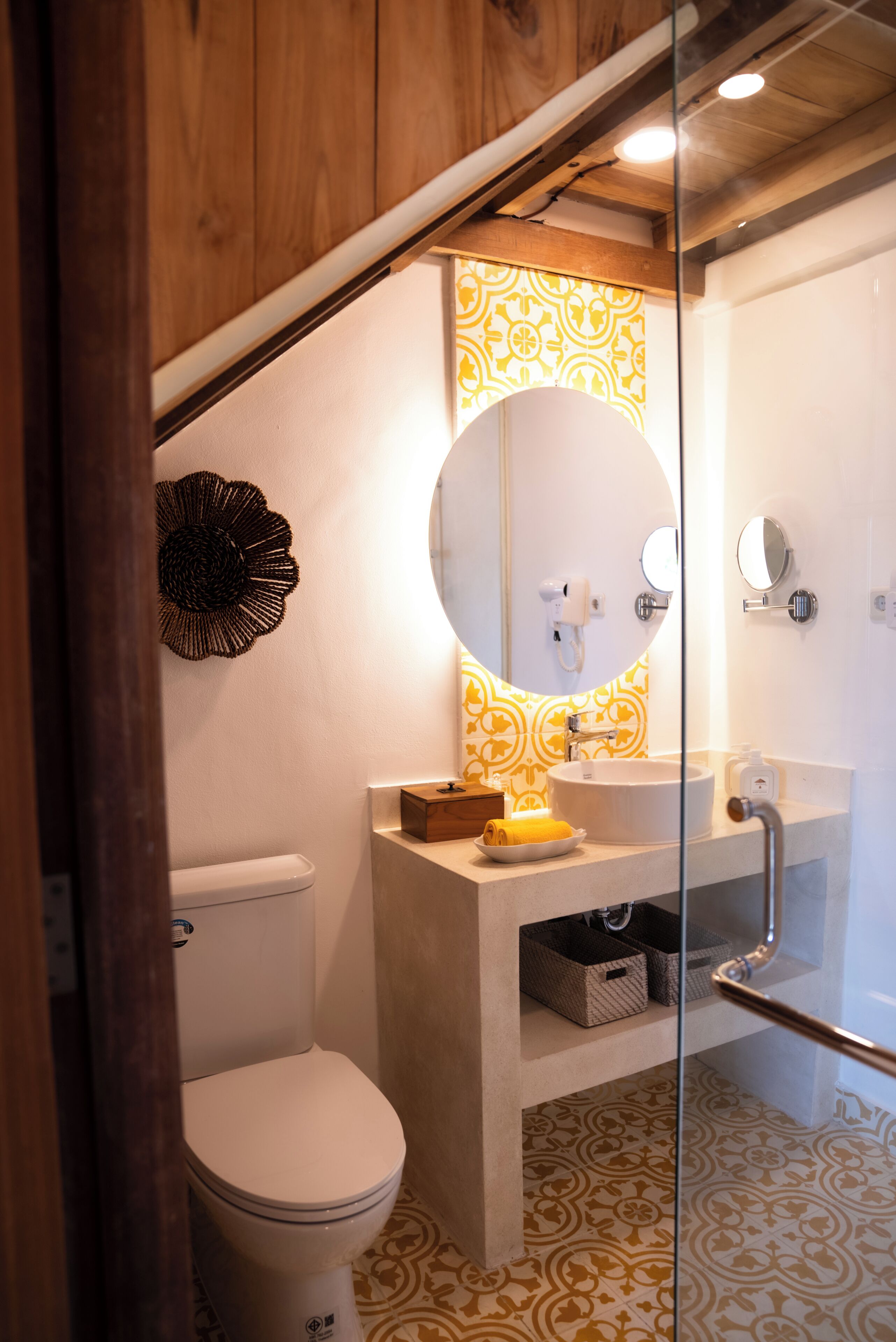 Une salle de bain avec des toilettes, un lavabo et un miroir.