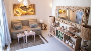 Un salon moderne comprenant un canapé, une table basse, une table d’appoint, une lampe, des objets de décoration et un miroir.