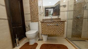 Bañera con ducha, toallas, jabón, shampoo