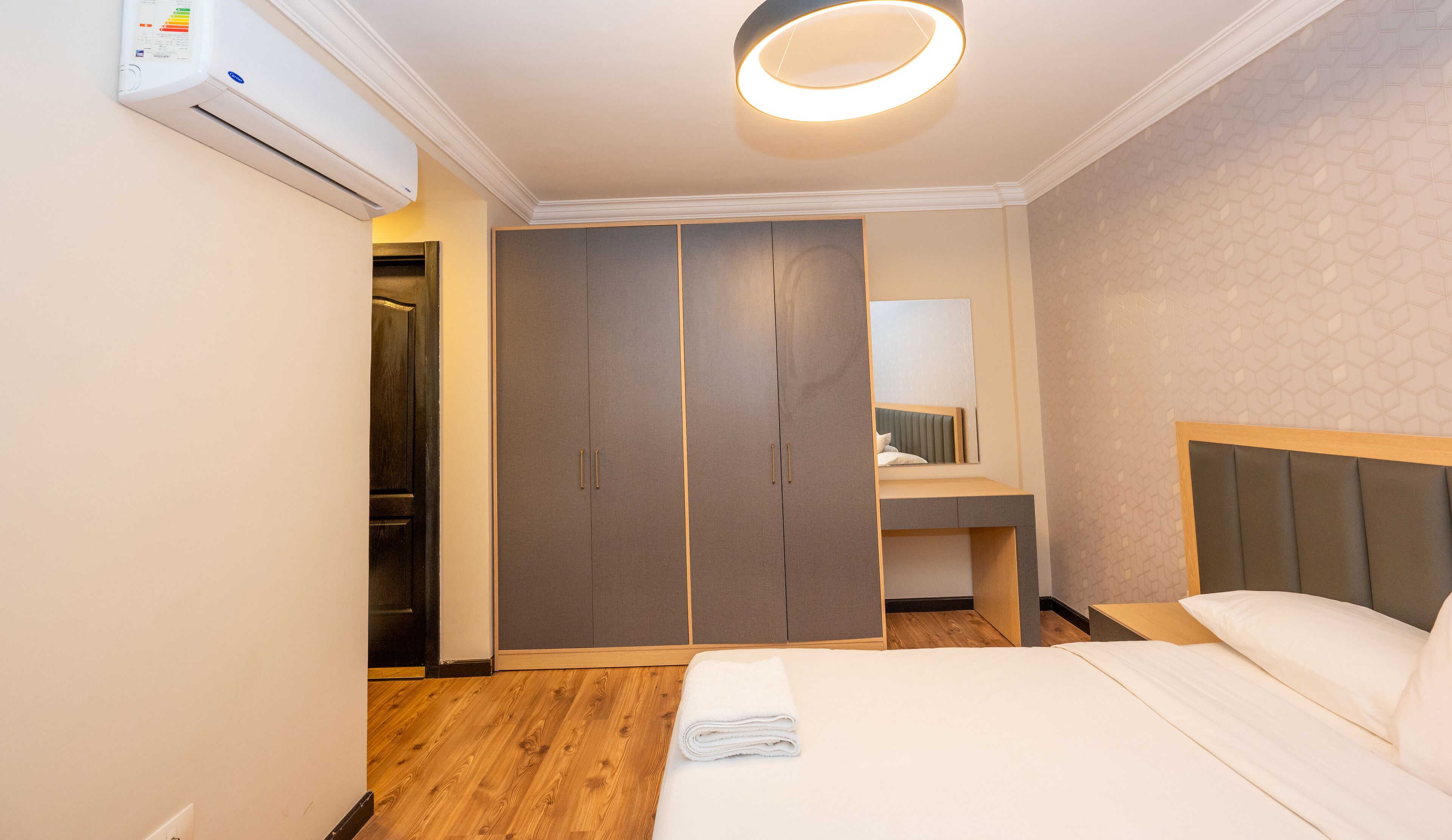 Ein Hotelzimmer mit einem Bett, einem Kleiderschrank, einem Spiegel und einem kleinen Badezimmer.