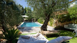 A private pool area with lounge chairs and a stone wall. - Peaceful farmhouse surrounded by olive trees.  Only 15 minutes from beaches and mountains (Opio)