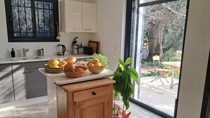 A kitchen with a wooden cabinet, a fruit bowl, and a potted plant. - Peaceful farmhouse surrounded by olive trees.  Only 15 minutes from beaches and mountains (Opio)