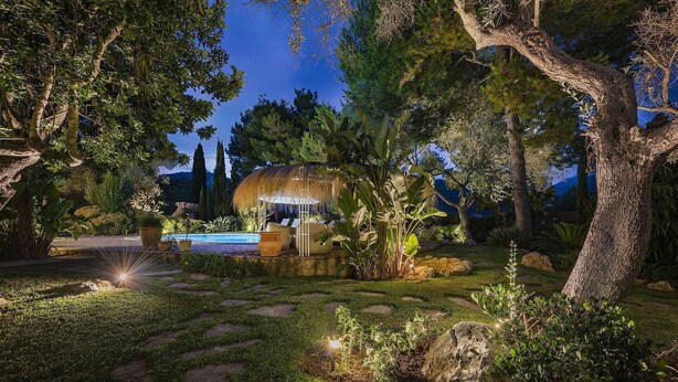 A well-lit outdoor area with a pool, seating, and lush greenery. - My Rental Homes - Can Cabana with private pool, air conditioning and wifi (Pollença)