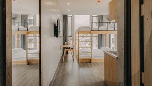 A modern hostel room with bunk beds, a wooden table, and a chair. - SNite Hotel & Dorm-Danang Dragon Bridge (Da Nang)