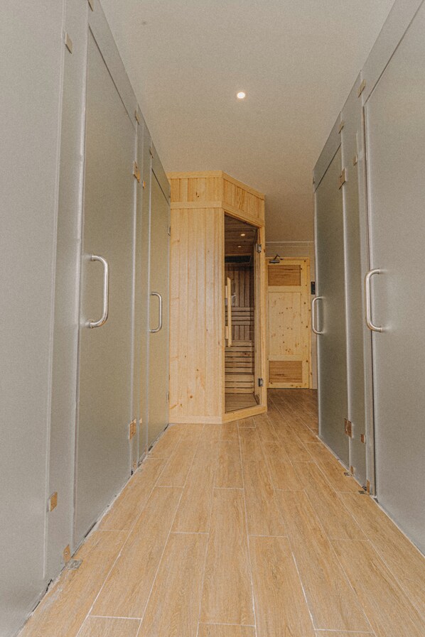 A hallway with lockers on both sides and a wooden door at the end. - SNite Hotel & Dorm-Danang Dragon Bridge (Da Nang)