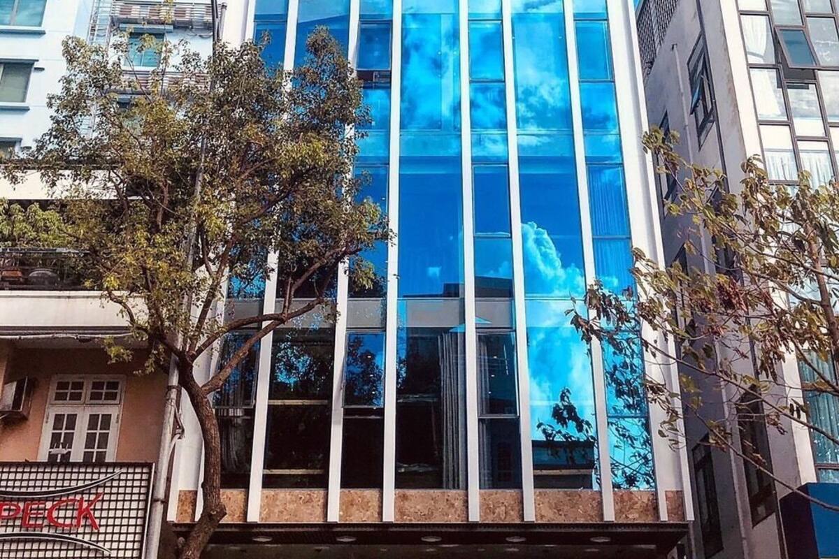 Un edificio moderno de gran altura con fachada de vidrio que refleja el cielo.