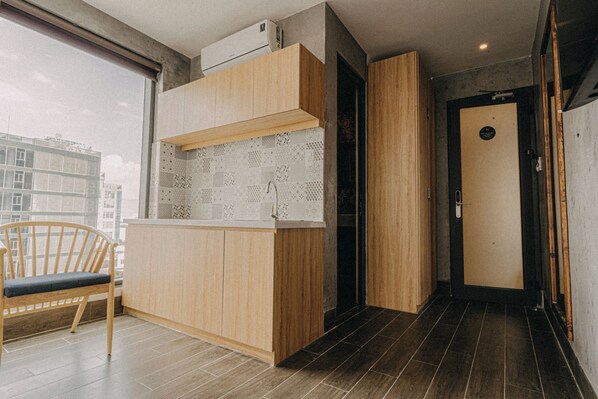 Une cuisine moderne avec des meubles en bois, un évier encastré et une fenêtre donnant sur un paysage urbain.