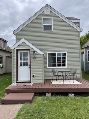 A two-story house with a front porch, a mailbox, and a number '914' on the door. - House of the Changing Sky (Superior)