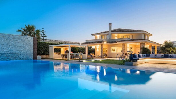 A modern house with a swimming pool, outdoor seating, and a well-lit patio area. - Villa Agorà with private pool - My Rental Homes (Syracuse)