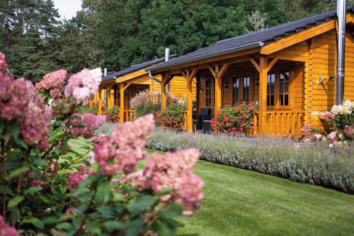 Eine Holzhütte mit Veranda und einem gepflegten Garten.
