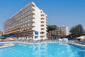 En säsongsöppen utomhuspool, parasoller och solstolar