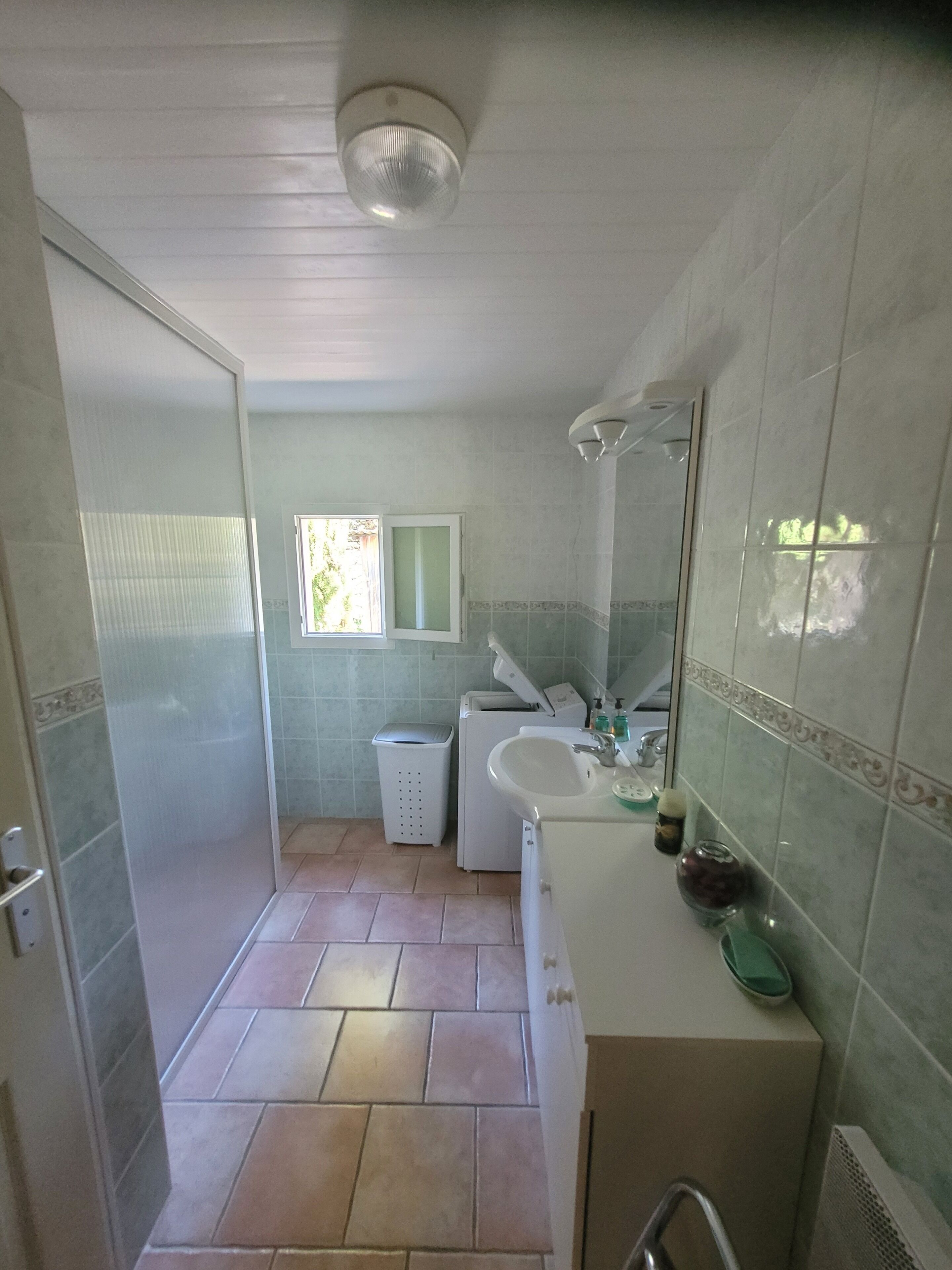A bathroom with a sink, mirror, and a window.