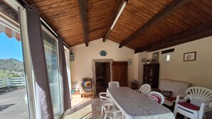 Un comedor con una mesa y sillas, techo de madera y vistas al exterior.