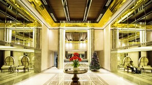 Eine geräumige Lobby mit einem runden Tisch in der Mitte, Sitzbereichen und einem Weihnachtsbaum.