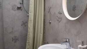 A bathroom with a toilet, sink, and shower.