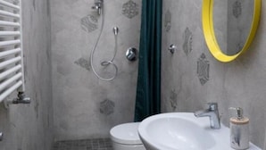 A bathroom with a shower, toilet, sink, and a mirror with a yellow frame. - B&B MilleCulure: Charming double room with private bathroom  (Napoli)