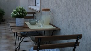 Una mesa de madera con una planta en maceta, un bol, un vaso y una jarra sobre un tapete a cuadros.