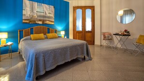 Une chambre à coucher avec un lit, une table de chevet, une chaise, une table et une porte.
