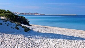 Une plage de sable blanc bordée d’une eau d’un bleu cristallin.