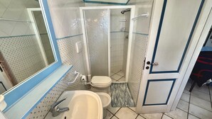 A bathroom with a sink, toilet, and shower.