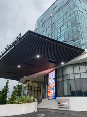 A modern building with a glass facade and a sign reading "LOBBY DROP OFF". - kozi square, kozi 8 (Kuching)
