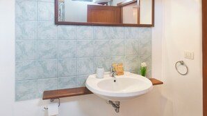 A bathroom with a white sink, a mirror, and a towel ring on the wall. - Machin 3 - One Bedroom Apartment, Sleeps 2 (Alghero)