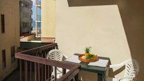 Ein Balkon mit Tisch, Stühlen und einem Blumentopf.
