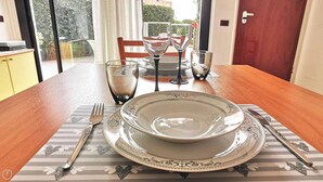 A dining table set with a plate, bowl, fork, knife, and glass.