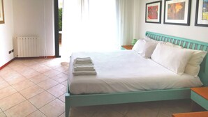 A bedroom with a bed, a radiator, and a window.