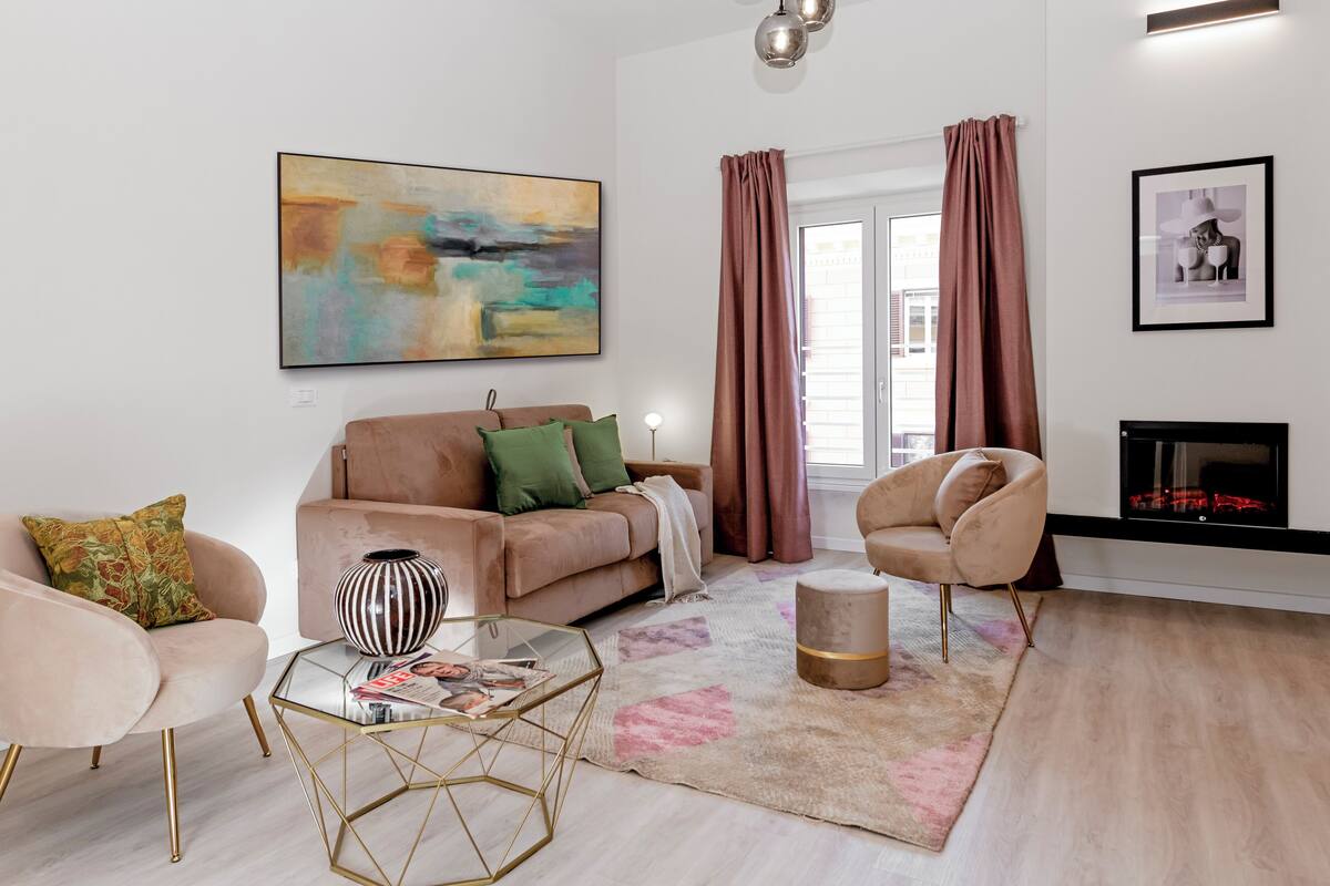 A modern living room with a sofa, armchairs, a coffee table, and a fireplace.
