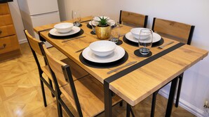 Une table à manger dressée avec des assiettes, des bols, des verres et des couverts.