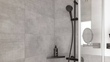 A modern shower with a handheld showerhead and a fixed wall-mounted head, a glass door, and a small shelf with toiletries.