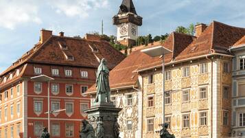 A public square with a statue, historic buildings, and a clock tower.