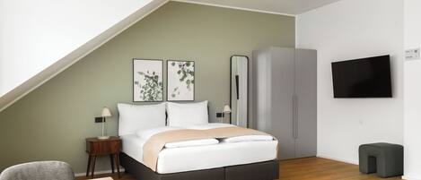 A modern bedroom with a bed, bedside tables, a wardrobe, a TV, and a mirror.