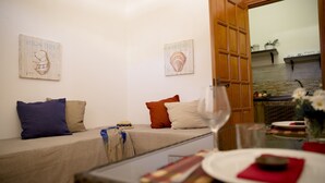 A cozy room with a bed, a dining table with a glass of wine, and artwork on the walls. - Villa I 2 Pini (San Vito Lo Capo)