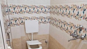 Une salle de bain avec des toilettes, un lavabo et une douche.